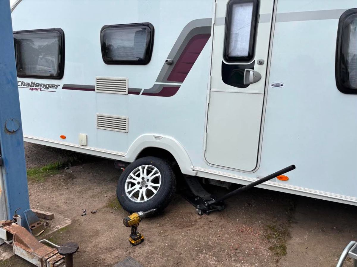 Swift Challenger Sport caravan on a jack with the wheel and impact gun on the ground