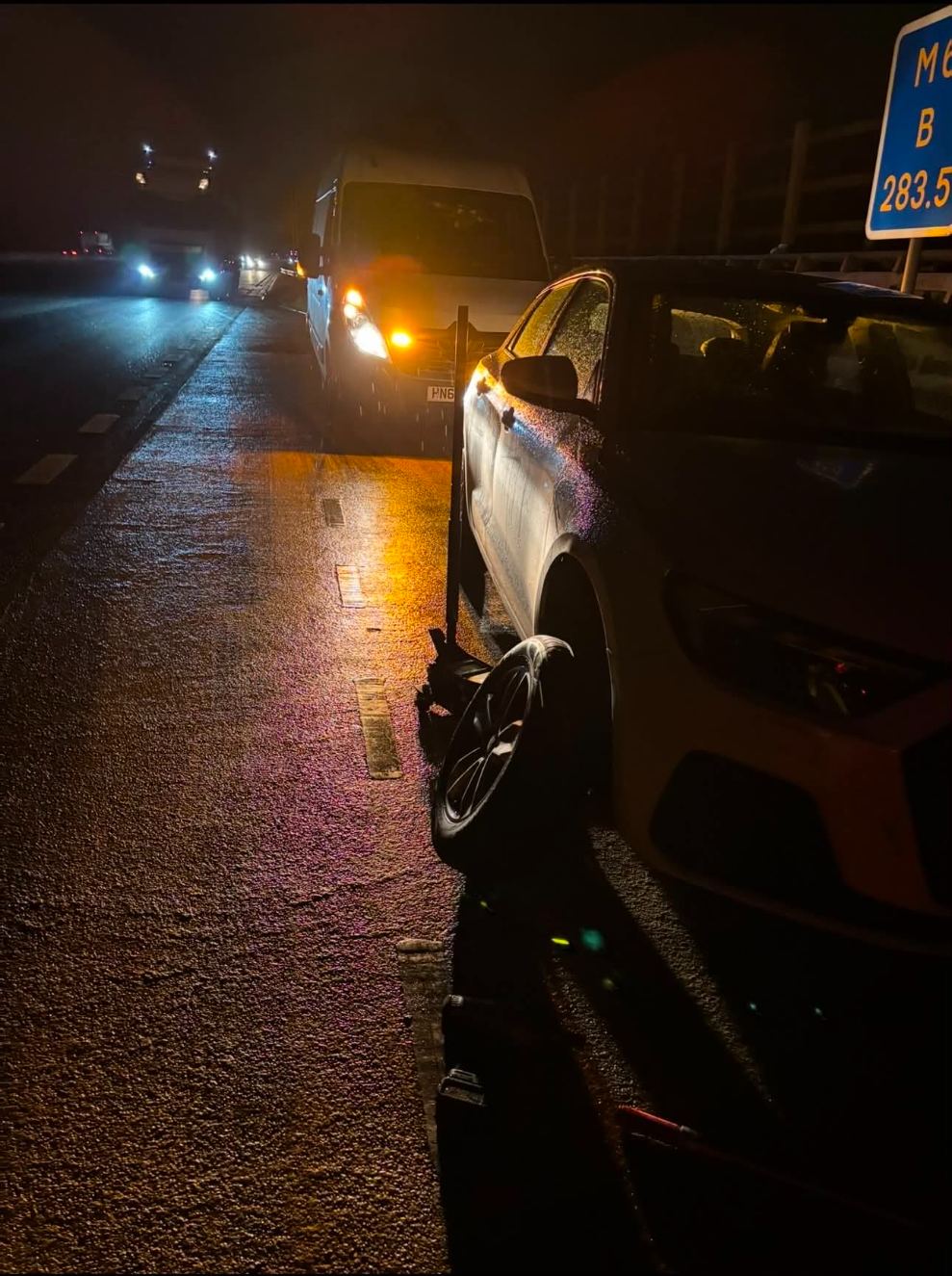 Night-time tyre change on the M6 hard shoulder near junction 15, DMS van with hazards on