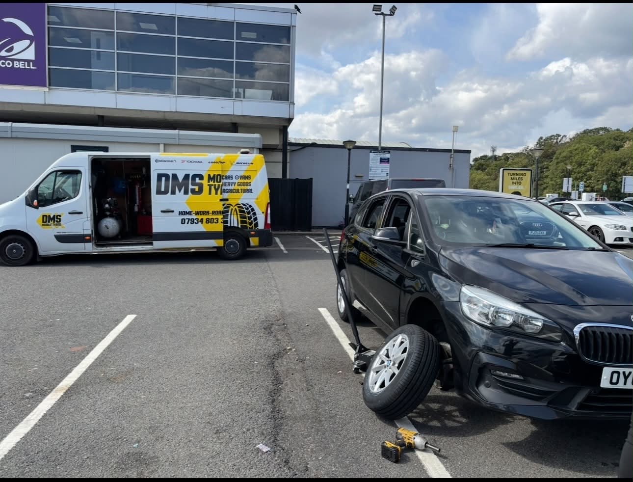 DMS Mobile Tyres van fitting a tyre in the car park at Keele services on the M6